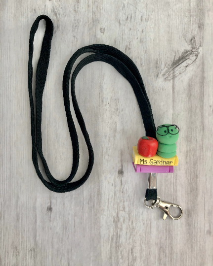 Teacher lanyard with books and caterpillar and apple